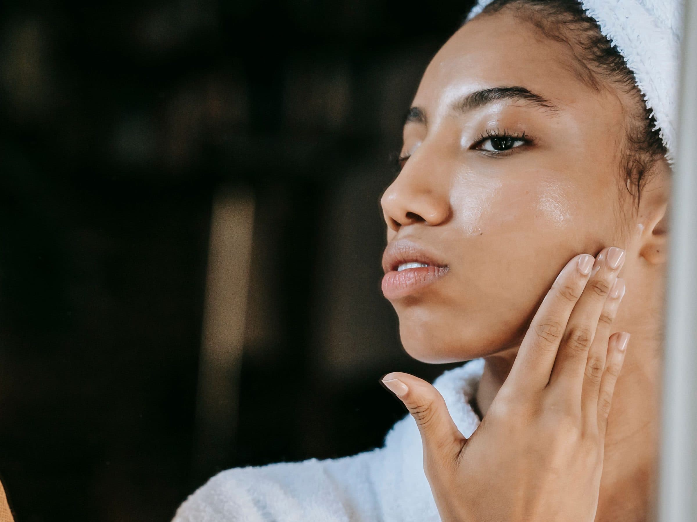 Close up of a woman touching her cheek during her skincare routine